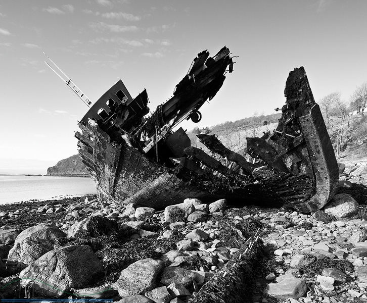 slides/Ship wreck.jpg boat,scotland,wreck,beach,braoke,shore,water,sea,ocean,clouds,black and white,encrusted,debris,fire damage Ship wreck